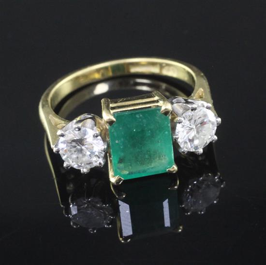 A modern 18ct gold, emerald and diamond three stone ring, size M.